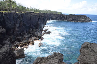 Scenic view of rocks in sea against sky