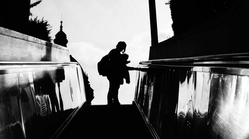 Silhouette man standing on motorcycle