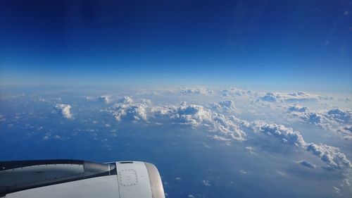 Airplane flying over clouds against blue sky