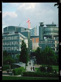 Buildings in city against cloudy sky