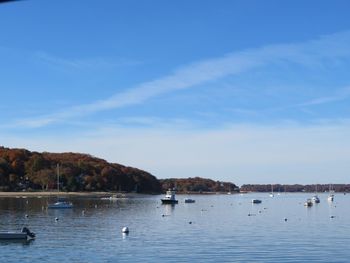 Sailboats in sea against sky