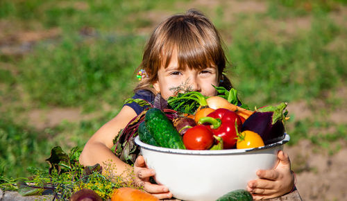 Portrait of girl with fresh bowl of vegetables