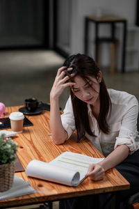 Stressed asian business woman working with marketing report. business financial concept.