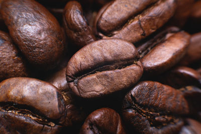 Close up extreme macro group of roasted brown or black coffee beans background in shallow depth of