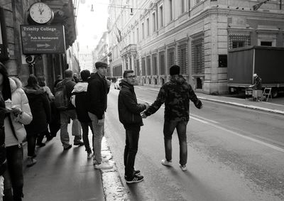 People walking on road along buildings