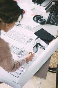 Architect looking at blueprint in office at home