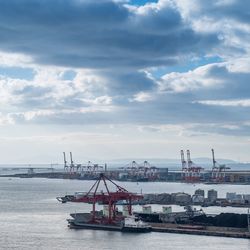 Boats in sea against cloudy sky