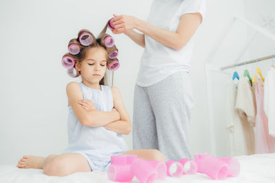 Full length of mother and girl sitting on floor