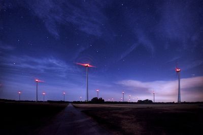 Road amidst field against sky at night