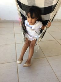 Girl sitting on hammock at home