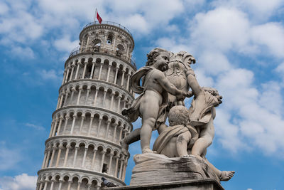 Low angle view of statue of historical building against cloudy sky