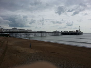 Pier on sea against cloudy sky