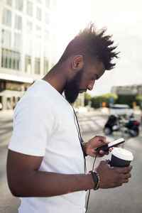 Young man in profile using smartphone