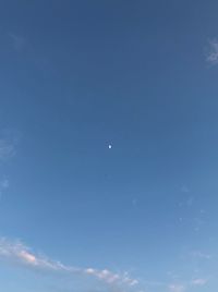 Low angle view of moon against blue sky