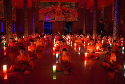 Group of people sitting in illuminated building at night