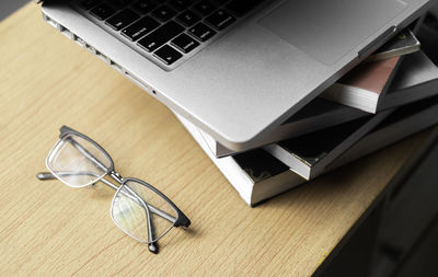 High angle view of laptop and eyeglasses on table