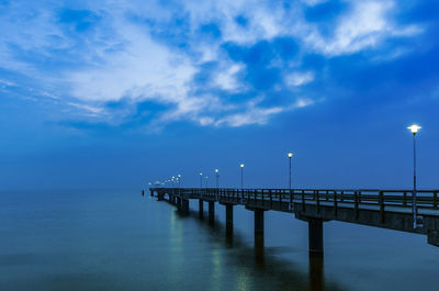 Pier over sea against blue sky