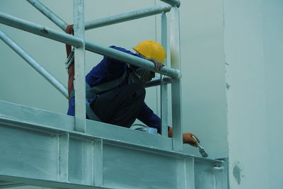 Construction worker painting railing