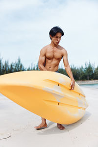 Rear view of shirtless man standing on snow covered landscape