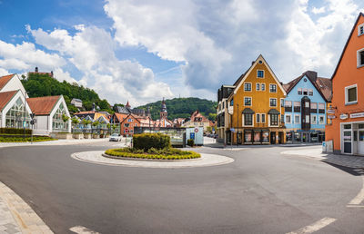 Houses by street in town against sky