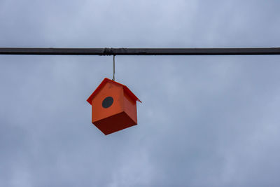 Low angle view of clothespins hanging on clothesline against sky