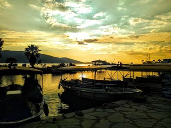 Boats moored in marina at sunset