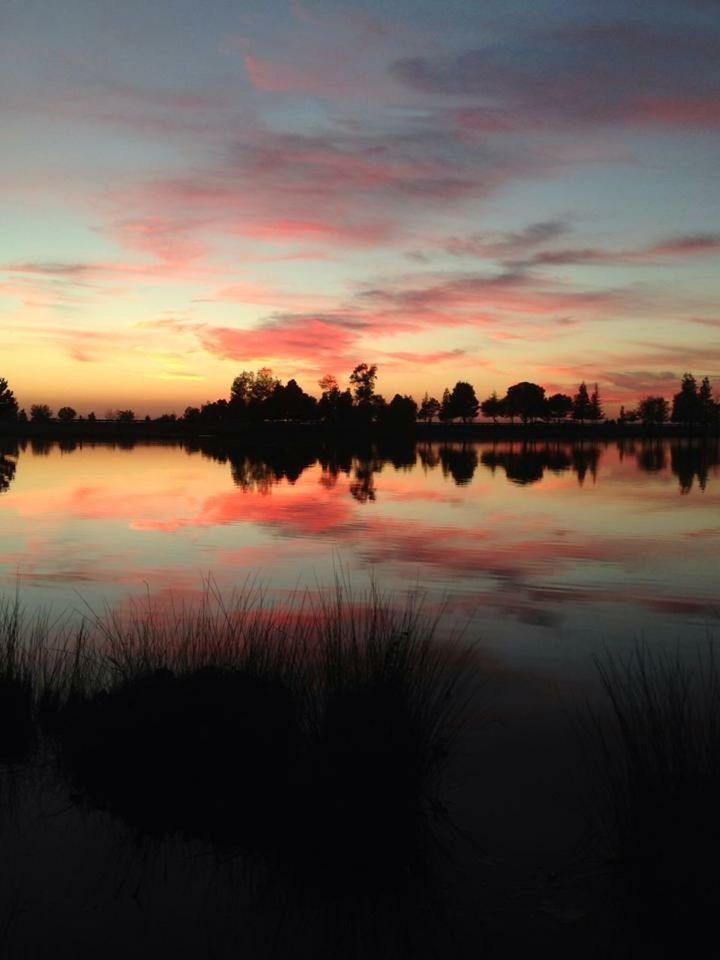 SCENIC VIEW OF CALM LAKE AT SUNSET