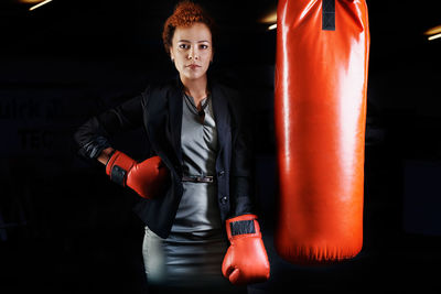 Portrait of woman standing by punching bag