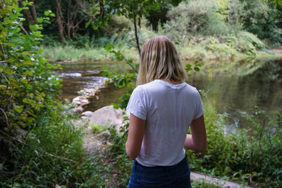 Rear view of girl standing in forest