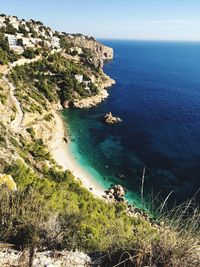 High angle view of cliff by sea against sky