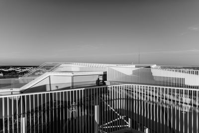 Fence by building against clear sky