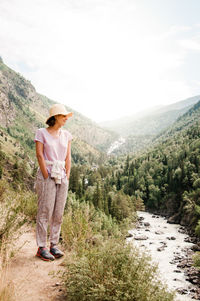 Woman standing on mountain against sky