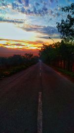 Road in city against sky at sunset