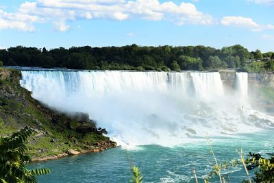 Scenic view of waterfall against sky