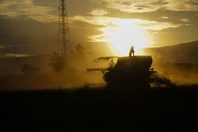 Combine harvester in a cloud of dust during harvesting. 