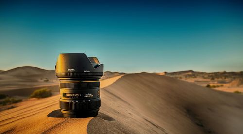 Electric lamp on desert against clear blue sky