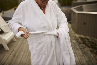 Mid section of woman tying dressing gown