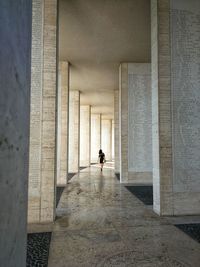 Woman walking in corridor of historic building