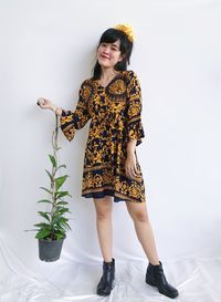 Full length of young woman standing against wall