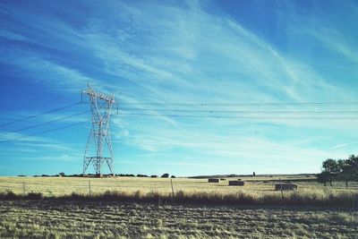 Electricity pylon on field against sky