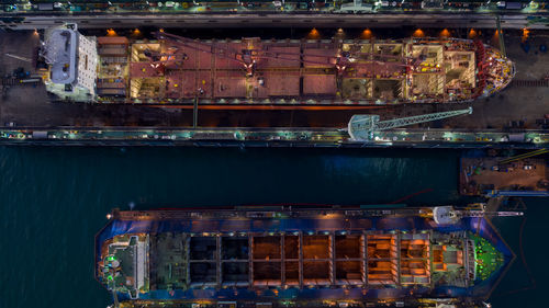 Aerial view container ship and oil in shipyard for repair at night. can use for shipping 