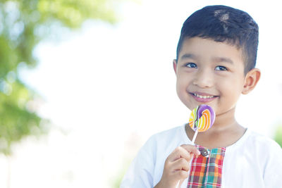 Portrait of smiling boy holding camera