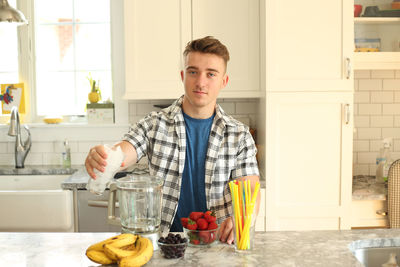 Portrait of smiling young man standing at restaurant