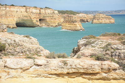 Rock formations by sea against sky