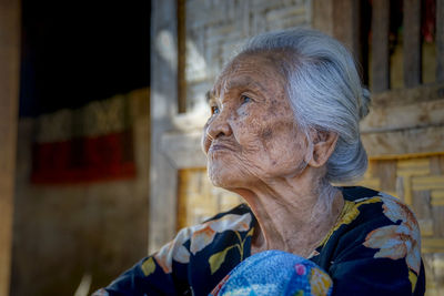 Close-up of senior woman looking away outdoors