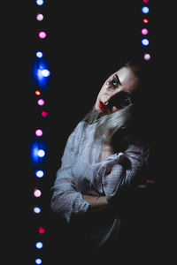 Woman with face paint looking away at night