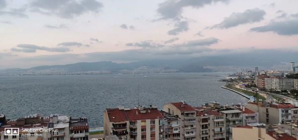 High angle view of city by sea against sky