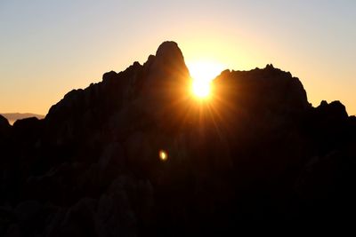 Low angle view of silhouette rocks against sky during sunset