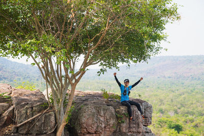 Full length of boy sitting on rock