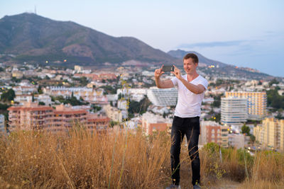 Full length of man standing on townscape against sky